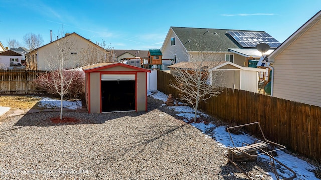 view of yard featuring an outbuilding, a shed, a fenced backyard, and a residential view