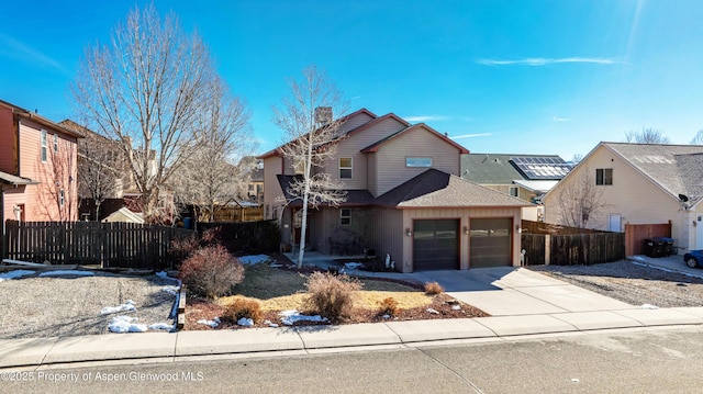 view of front of property featuring a garage, concrete driveway, fence, and a residential view