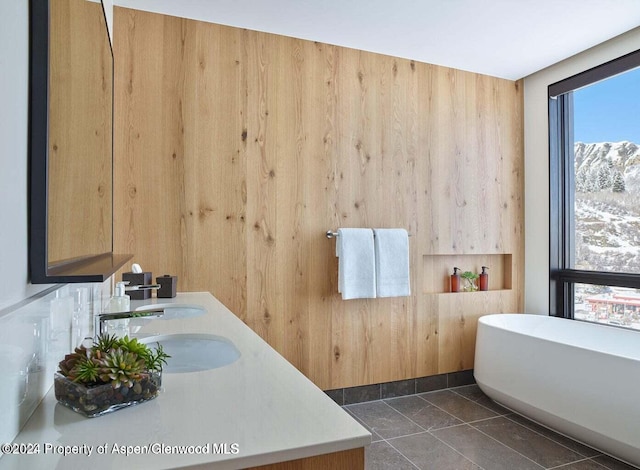 77 Wood Rd Unit 507-10, Snowmass Village, CO 81615 - full bathroom with a freestanding bath, wood walls, double vanity, and healthy amount of natural light