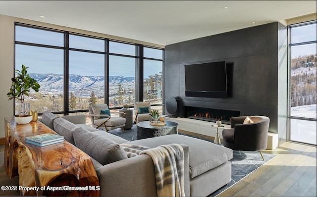 77 Wood Rd Unit 507-10, Snowmass Village, CO 81615 - living room featuring wood finished floors, floor to ceiling windows, plenty of natural light, and a large fireplace