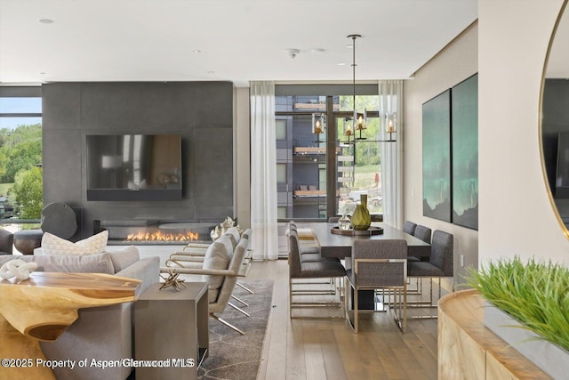 77 Wood Rd Unit 507-10, Snowmass Village, CO 81615 - living area featuring wood-type flooring, expansive windows, healthy amount of natural light, and a fireplace