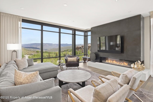 77 Wood Rd Unit 507-10, Snowmass Village, CO 81615 - living room featuring floor to ceiling windows, wood finished floors, a glass covered fireplace, and recessed lighting
