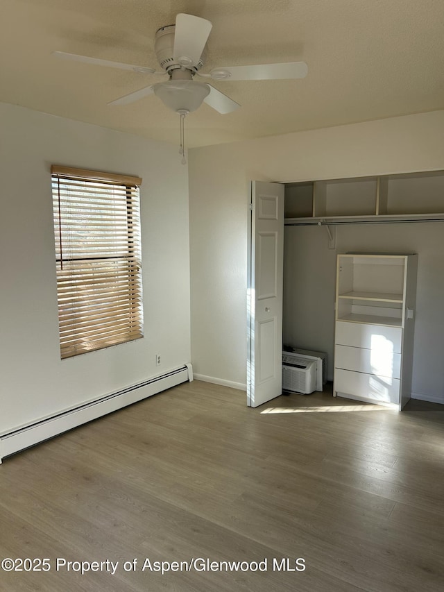 1527 Blake Ave Unit 201, Glenwood Springs, CO 81601 - unfurnished bedroom with a baseboard radiator, wood finished floors, a closet, and ceiling fan