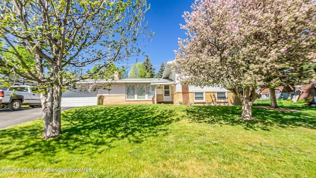 1028 Breeze St, Craig, CO 81625 - tri-level home with brick siding, a front yard, and driveway