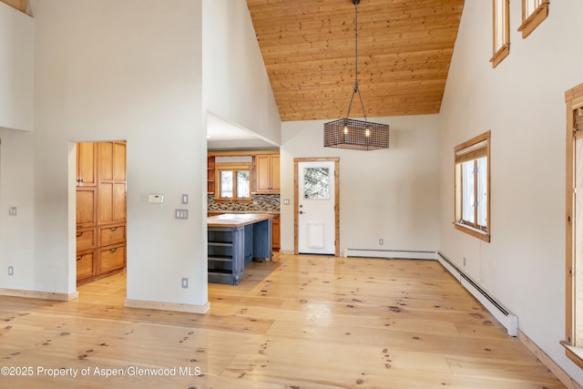 interior space featuring high vaulted ceiling, baseboard heating, and light wood-type flooring