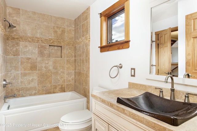 full bathroom featuring vanity, tiled shower / bath combo, and toilet