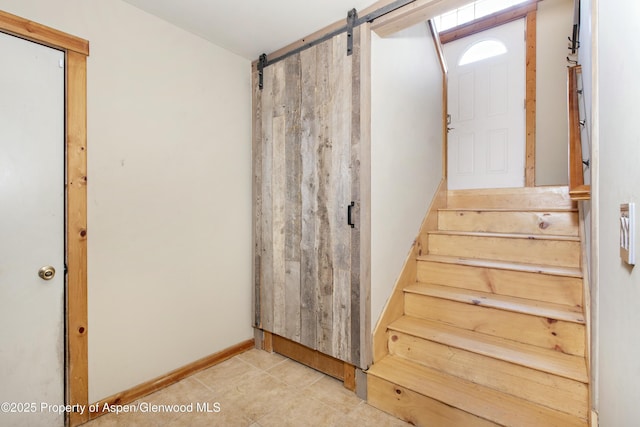 staircase with tile patterned flooring and a barn door