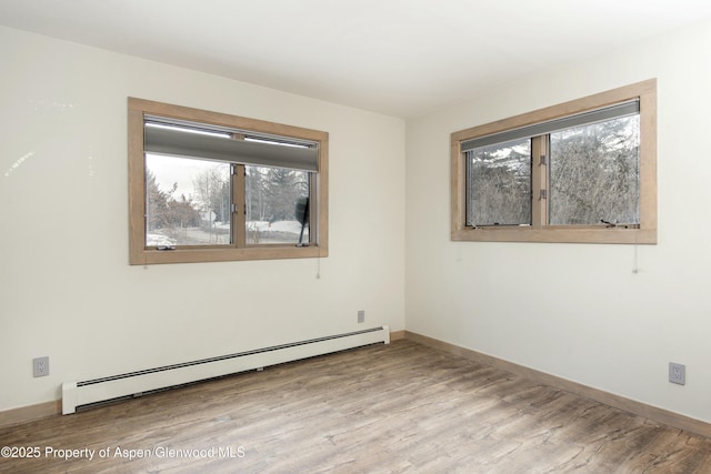 empty room featuring a baseboard radiator and light wood-type flooring