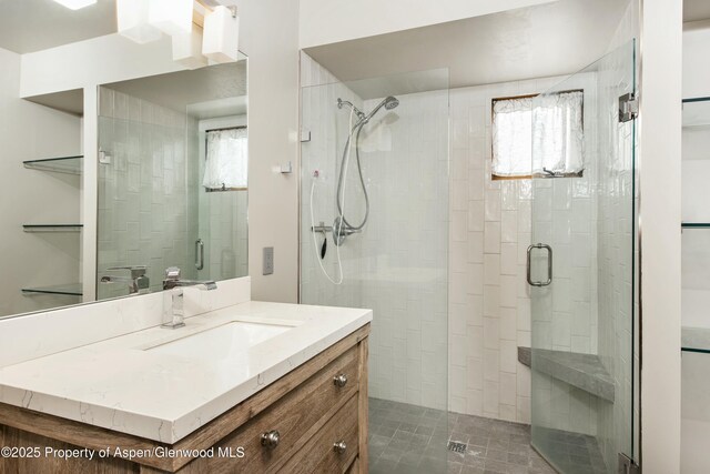 bathroom with vanity, a healthy amount of sunlight, and walk in shower