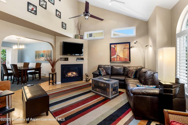 905 Meadow Run, Glenwood Springs, CO 81601 - living room with ceiling fan, high vaulted ceiling, arched walkways, a glass covered fireplace, and a chandelier