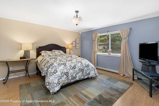 905 Meadow Run, Glenwood Springs, CO 81601 - bedroom with baseboard heating, crown molding, and wood finished floors