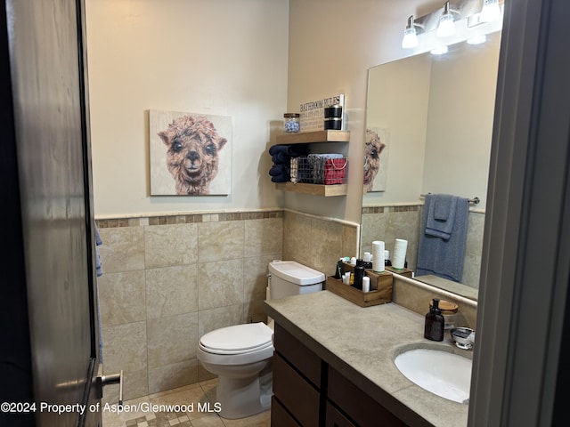 bathroom with tile patterned floors, vanity, tile walls, and toilet