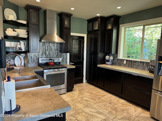 kitchen with sink, wall chimney range hood, stainless steel appliances, and tasteful backsplash