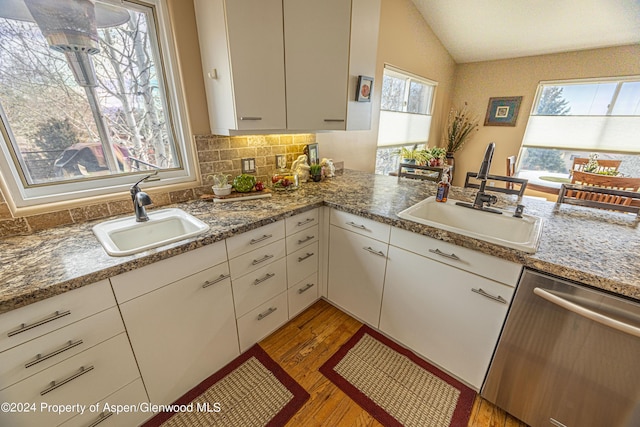 1001 Alta Ct, Craig, CO 81625 - kitchen featuring dishwasher, a sink, light wood-style flooring, lofted ceiling, and decorative backsplash