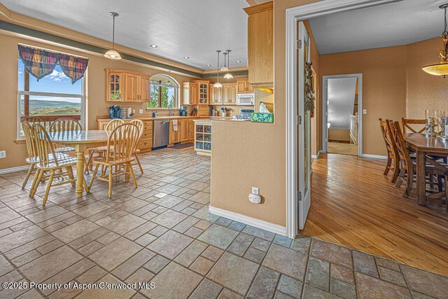 289 Lewis Ln, Craig, CO 81625 - kitchen with white microwave, dishwasher, baseboards, stone tile flooring, and light countertops