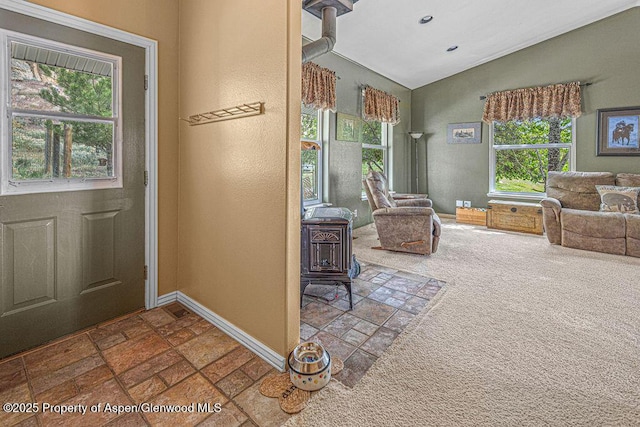 289 Lewis Ln, Craig, CO 81625 - carpeted foyer entrance with a wood stove, stone tile floors, lofted ceiling, plenty of natural light, and baseboards