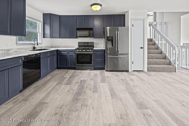 813 Finley Ln, Craig, CO 81625 - kitchen featuring black appliances, light wood-type flooring, light countertops, and blue cabinetry