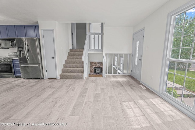 813 Finley Ln, Craig, CO 81625 - unfurnished living room featuring light wood-style flooring and stairs