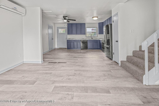 813 Finley Ln, Craig, CO 81625 - kitchen with a wall mounted air conditioner, stainless steel appliances, blue cabinets, light countertops, and a ceiling fan