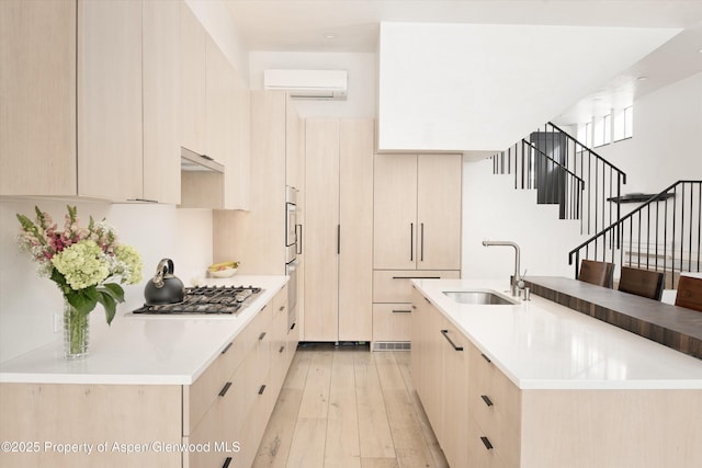 155 Lone Pine Rd Unit 2, Aspen, CO 81611 - kitchen with a wall mounted AC, light brown cabinets, stainless steel gas cooktop, and modern cabinets