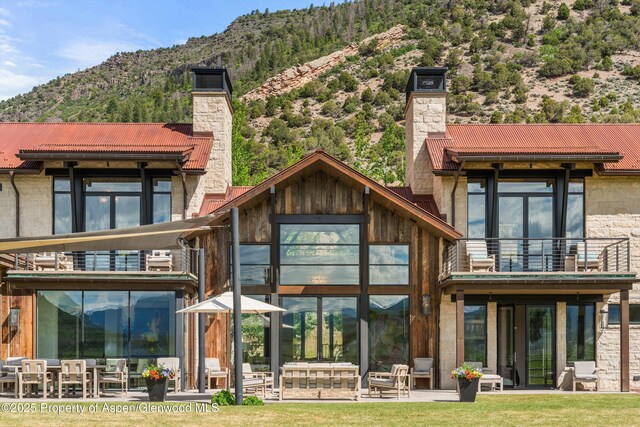 295 Aspen Valley Ranch Rd, Woody Creek, CO 81656 - rear view of house with a chimney, a balcony, a mountain view, and a tile roof