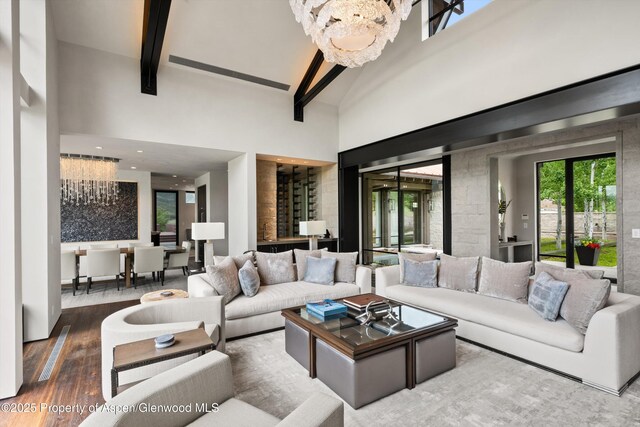 295 Aspen Valley Ranch Rd, Woody Creek, CO 81656 - living area featuring beamed ceiling, a high ceiling, wood finished floors, and healthy amount of natural light