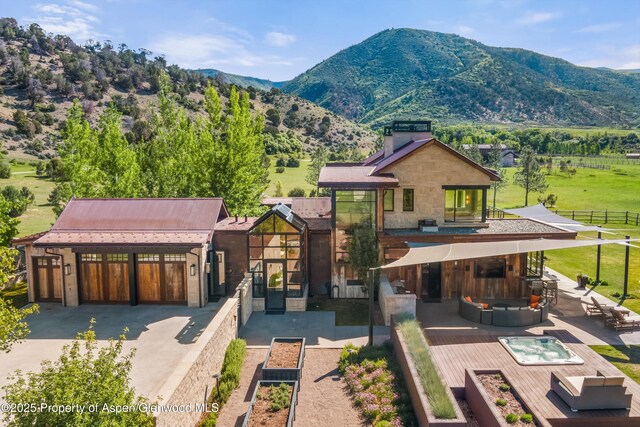 295 Aspen Valley Ranch Rd, Woody Creek, CO 81656 - view of front facade with an outdoor hangout area, a mountain view, a balcony, and a patio