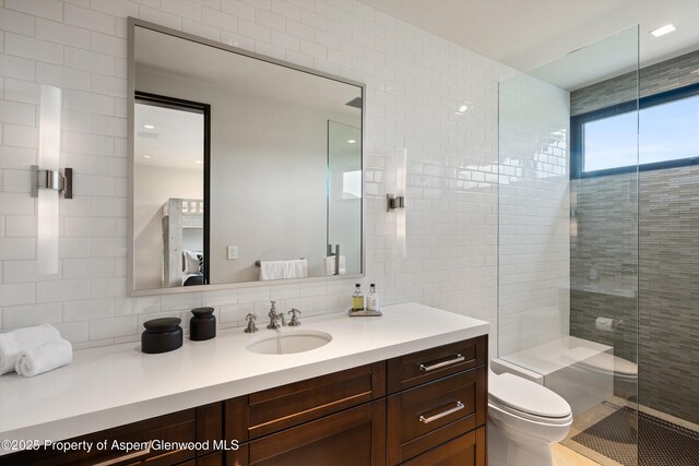 295 Aspen Valley Ranch Rd, Woody Creek, CO 81656 - full bathroom with toilet, vanity, tasteful backsplash, a tile shower, and tile walls