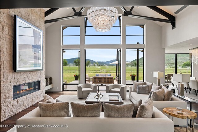 295 Aspen Valley Ranch Rd, Woody Creek, CO 81656 - living room with a mountain view, high vaulted ceiling, a chandelier, beam ceiling, and a glass covered fireplace