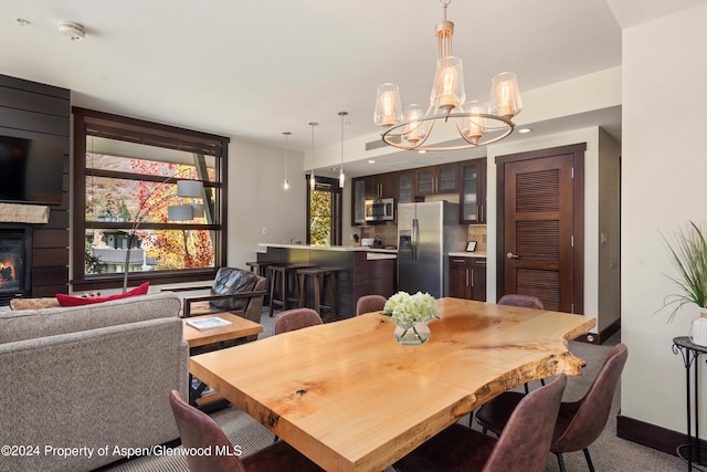 carpeted dining space featuring a notable chandelier