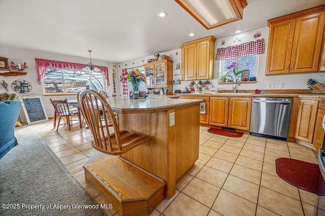 37 Pronghorn Rd, Craig, CO 81625 - kitchen with light tile patterned floors, light countertops, stainless steel dishwasher, a kitchen island, and a sink