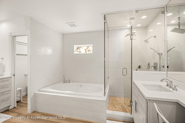 1195 E Cooper Ave Unit A, Aspen, CO 81611 - bathroom with vanity, wood finished floors, a shower stall, and a garden tub
