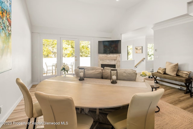 1195 E Cooper Ave Unit A, Aspen, CO 81611 - dining area with light wood finished floors, a stone fireplace, and high vaulted ceiling