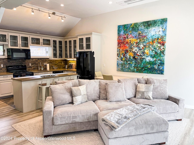1195 E Cooper Ave Unit A, Aspen, CO 81611 - living room featuring light wood-type flooring, vaulted ceiling, track lighting, and recessed lighting