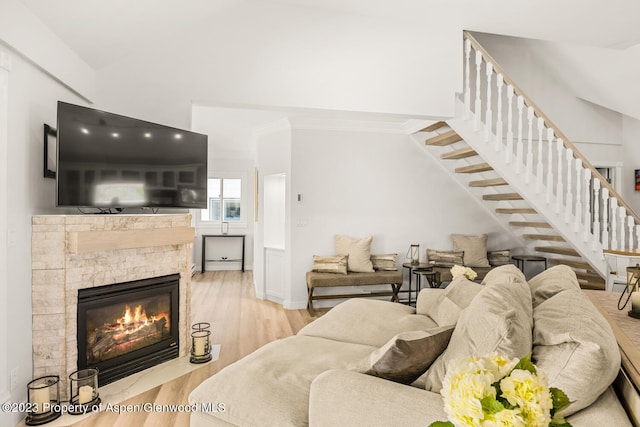 1195 E Cooper Ave Unit A, Aspen, CO 81611 - living area with stairs, wood finished floors, a stone fireplace, ornamental molding, and vaulted ceiling