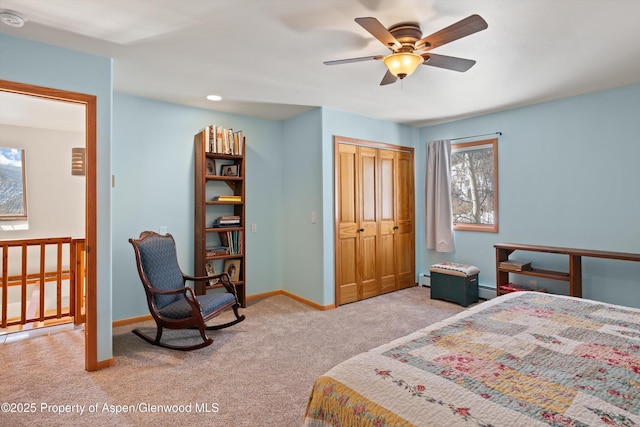 carpeted bedroom featuring a ceiling fan, baseboards, a closet, and a baseboard heating unit