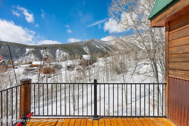 snow covered deck featuring a mountain view