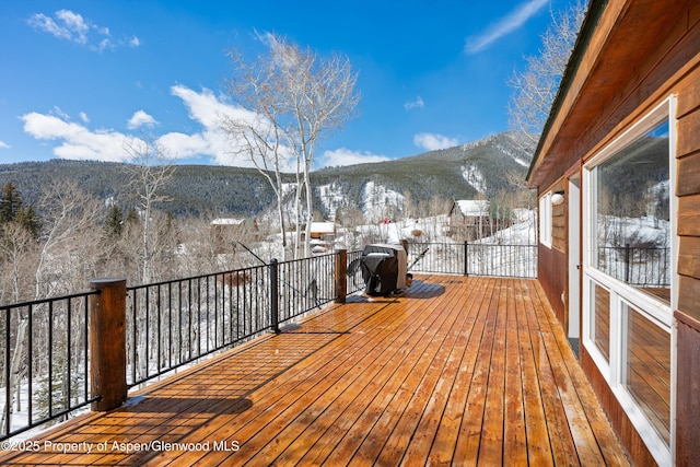 snow covered deck with a mountain view