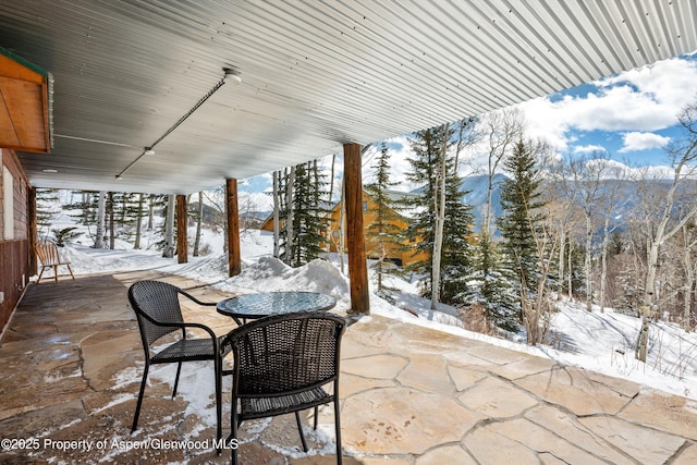 snow covered patio featuring outdoor dining area