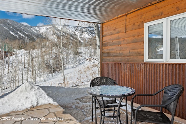 snow covered patio with a mountain view