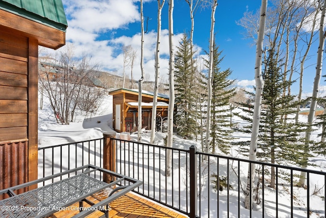 view of snow covered back of property