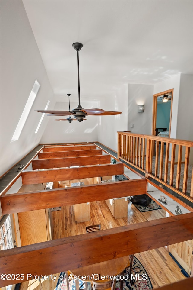 stairway with a skylight and a ceiling fan