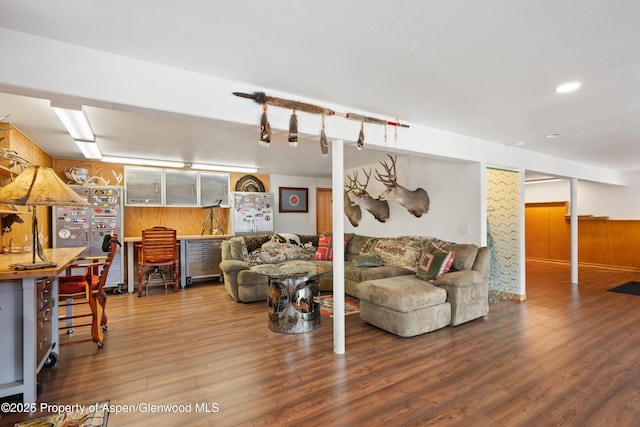 living room featuring recessed lighting, wood walls, and wood finished floors