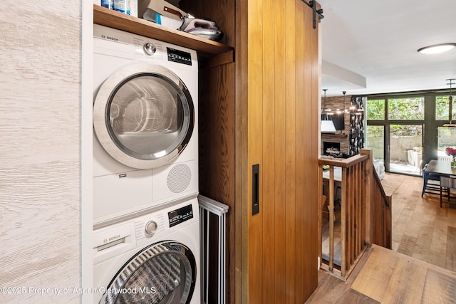 800 S Mill St Unit 105, Aspen, CO 81611 - laundry area featuring stacked washing machine and dryer and wood finished floors