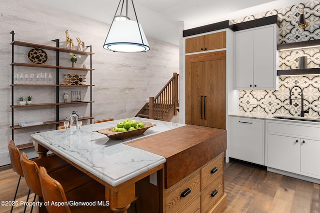 800 S Mill St Unit 105, Aspen, CO 81611 - kitchen with dark wood finished floors, backsplash, a sink, white cabinetry, and open shelves