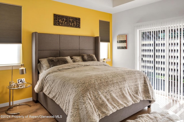 bedroom featuring access to exterior and hardwood / wood-style flooring