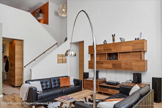 living room featuring a high ceiling and light wood-type flooring