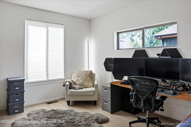 home office with light hardwood / wood-style floors