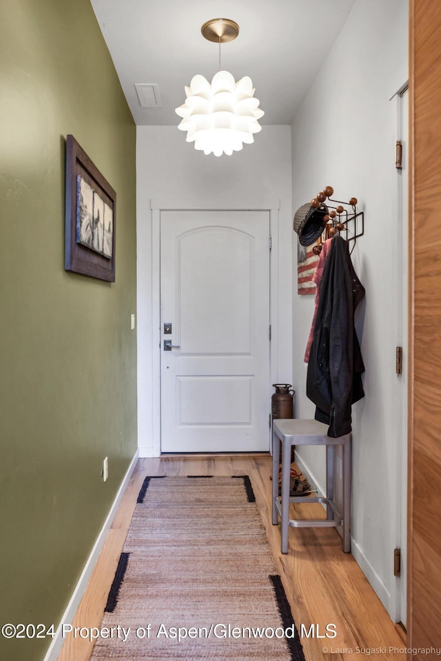 entryway with a chandelier and light wood-type flooring