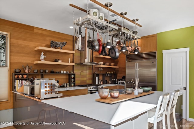 kitchen with wood walls, sink, and appliances with stainless steel finishes